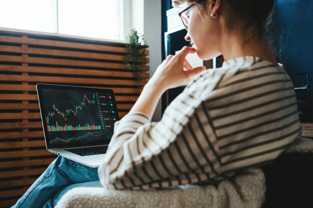 WomanInvestingInWorldStockMarketUsingHerLaptopAnd