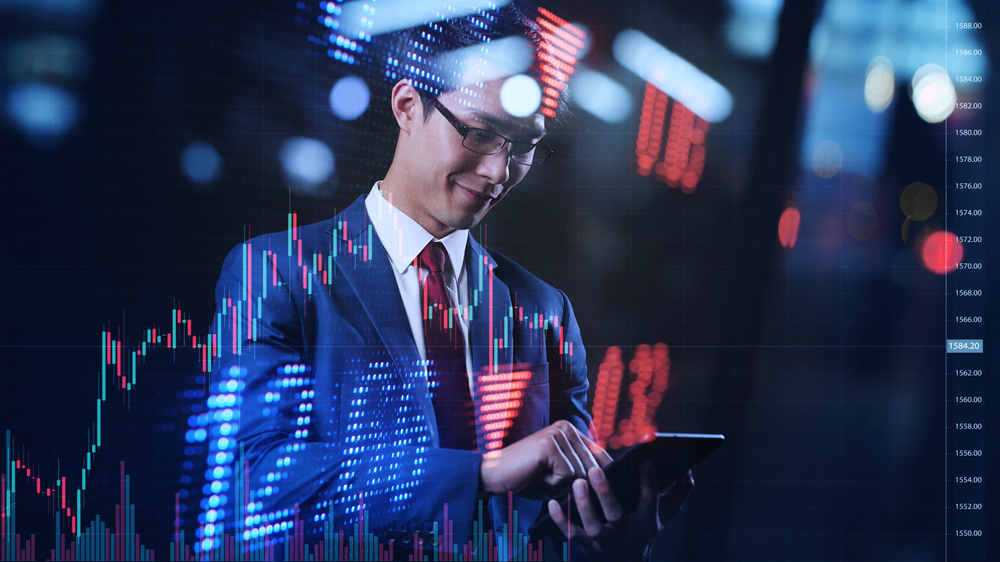 SmartAsianBusinessmanTypingFinancialDataOnMobilePhoneWith