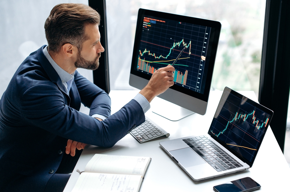 FocusedSmartSuccessfulCaucasianMaleStockInvestorBrokerSitsAt